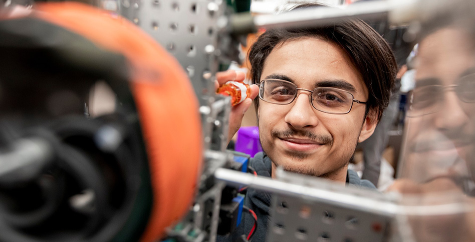 Student looking into 3D printer Student looking into 3D printer