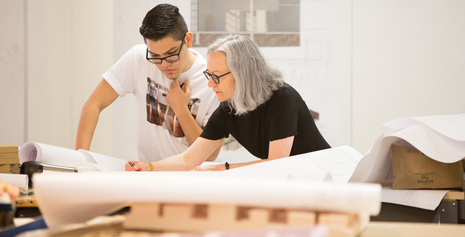 Students and faculty member working on blueprints Students and faculty member working on blueprints
