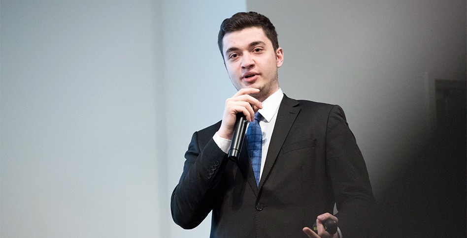 Student in suit speaking at microphone