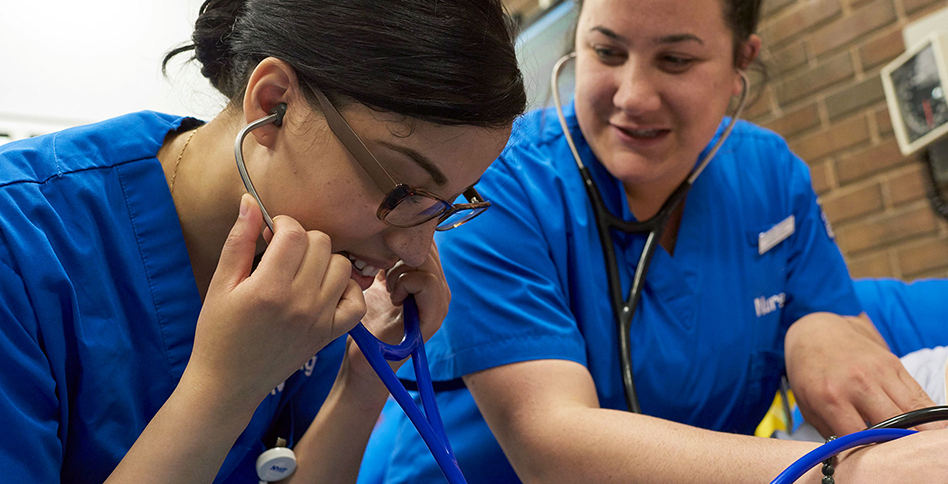 Student nurses listening to with stethoscopes