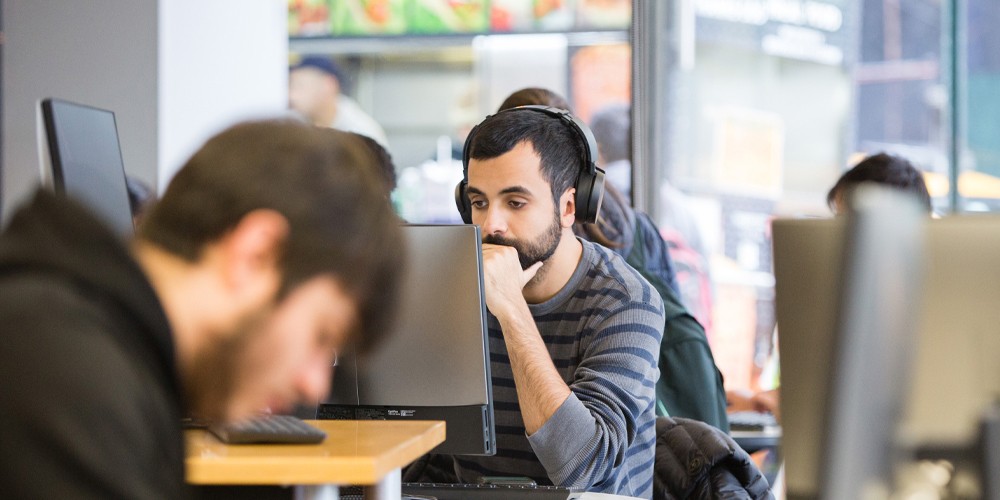 Student wearing headphones on computer.