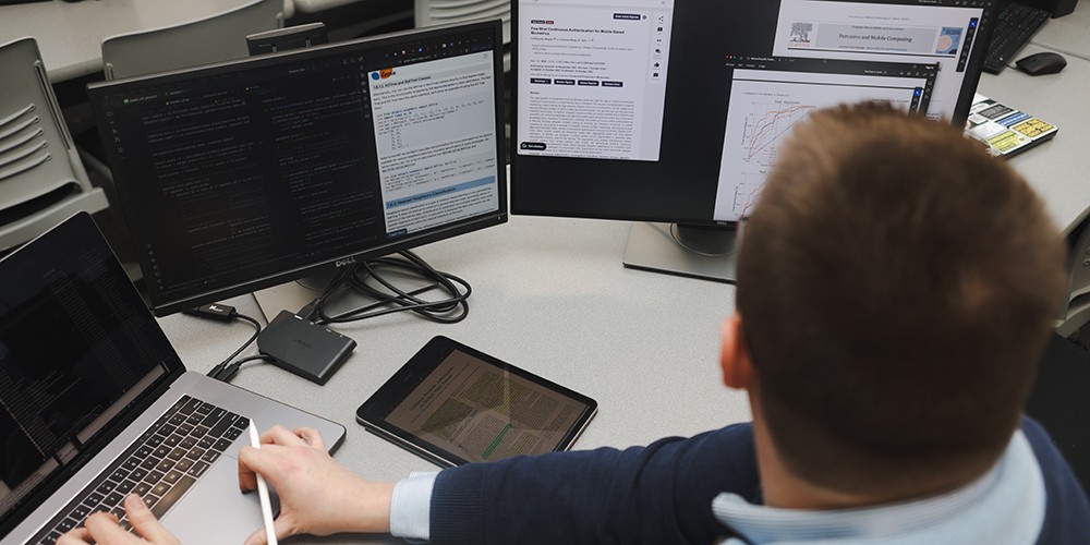 Business person working on multiple screens.