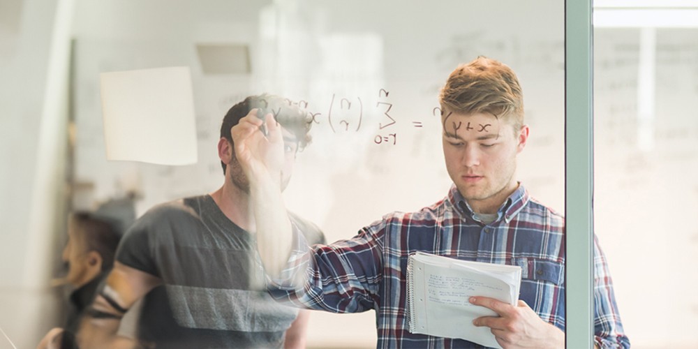Student writes formulas on whiteboard