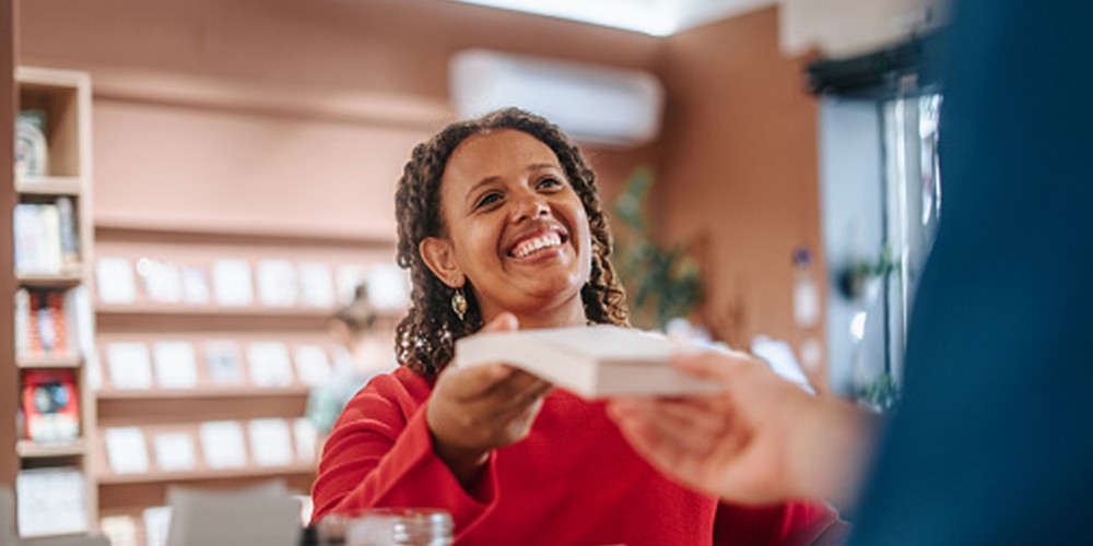 Woman passing a book to another person