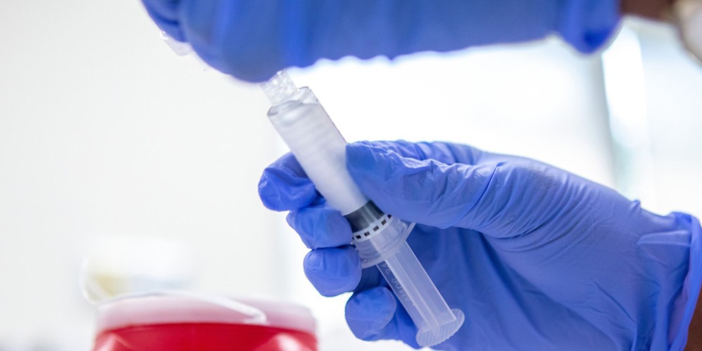 Hands holding a vial