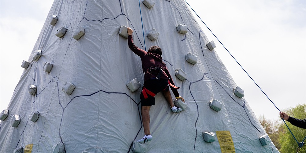Student climbing rock wall