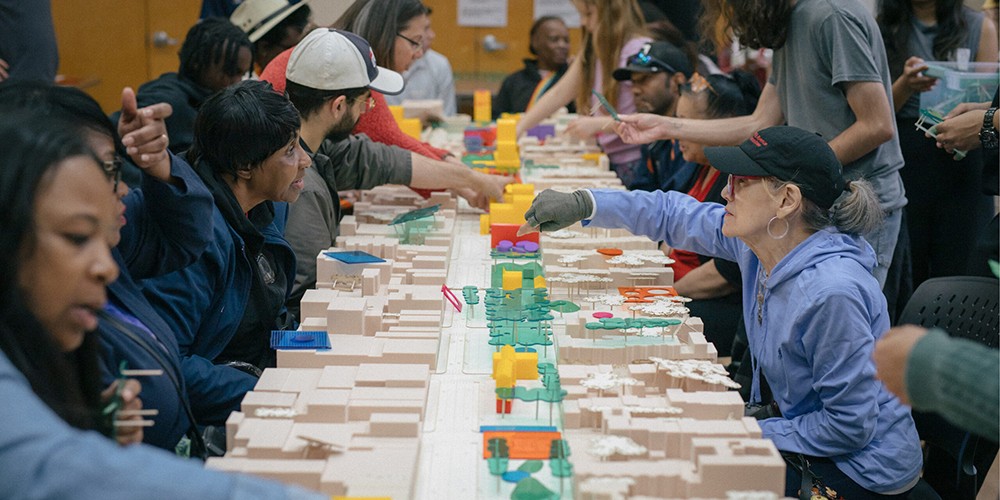 Two women work on model city street